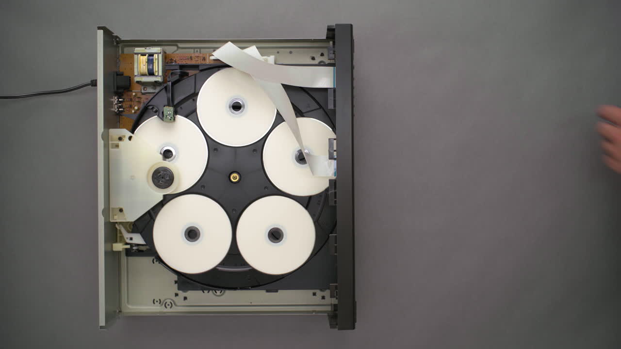 상단이 열린 5개의 디스크 플레이어에서 공 cd를 손으로 교체, 하향식