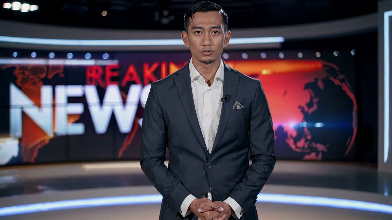 Un presentador de noticias está de pie con confianza en un estudio, capturado desde un ángulo de cámara frontal