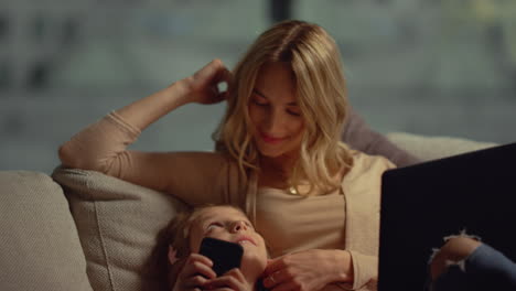 Mother-and-daughter-relaxing-gadgets.-Mom-and-child-using-computer-mobile-phone