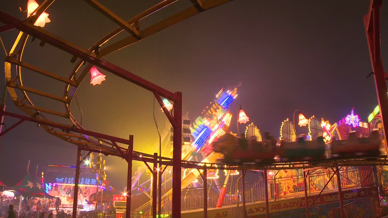 una pequeña montaña rusa en el carnaval de un parque de diversiones o en una feria estatal por la noche 1