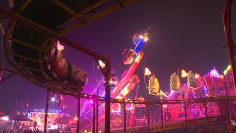 a small roller coaster at an amusement park carnival or state fair at night  1