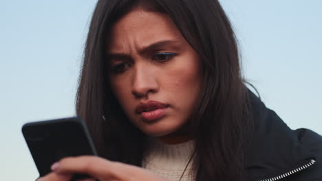 Sad Asian girl using mobile phone.
