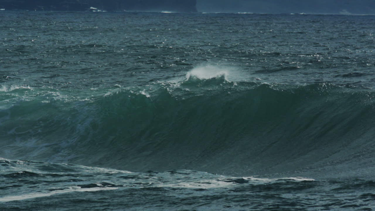 Dark water swells and collapses with loud misty spray and heavy energy, slow motion compression