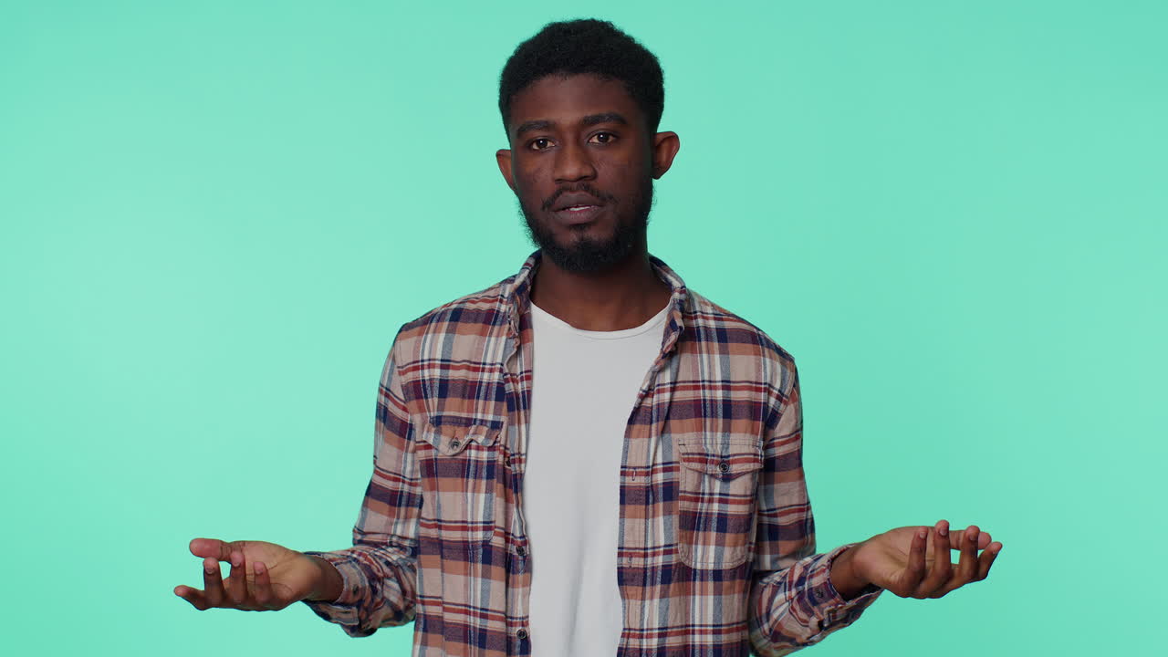 Clueless african american man raising hands in helpless gesture, confused by difficult question