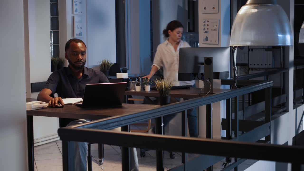 Corporate employee sending email on laptop at night