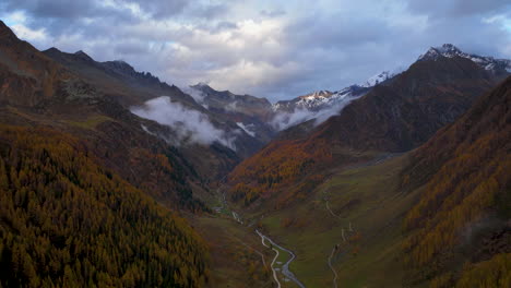Stunning-golden-Casere-woodland-valley-sunlight-and-cloud-passing-bottom-of-South-Tyrol-mountain-Hyper-lapse-aerial-view