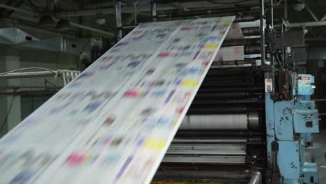 color printing of newspapers on large machines, conveyor. rolls of paper are drawn across the printing press. printing house. media, article, headline, daily news, print edition, journalism, politics