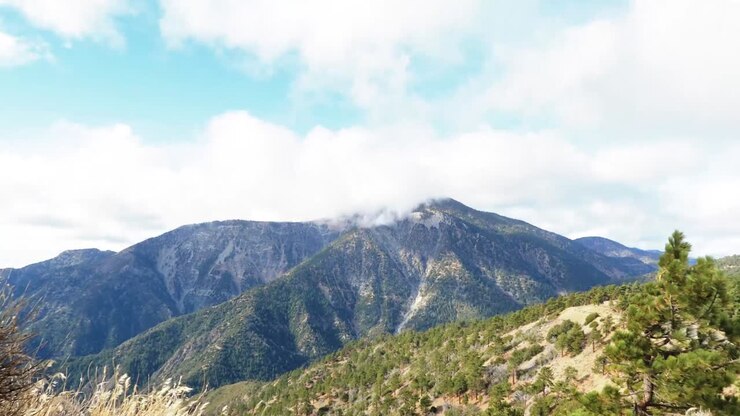 Montaña al fondo con nubes pasando en timelapse.