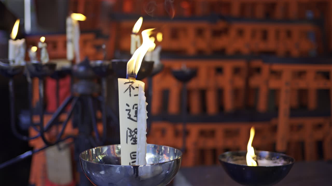 Fushimi Inari Shrine in Japan with candles flickering gently, illuminating inscriptions and creating a peaceful atmosphere. Translation on candle: ''Inari - God of Rice''