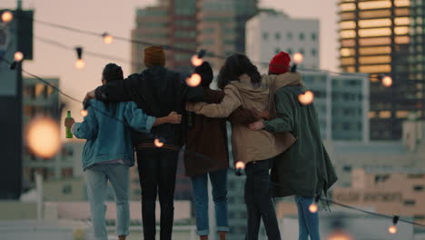 grupo feliz de amigos en el techo con los brazos levantados celebrando la amistad disfrutando de pasar el rato juntos bebiendo alcohol abrazando la libertad mirando el horizonte de la ciudad urbana al atardecer