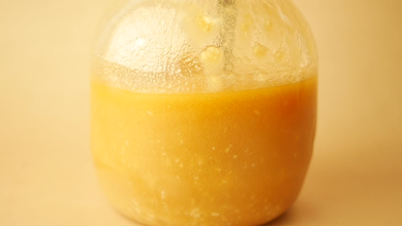 노란색 액체가 들어있는 유리 항아리의 클로즈업