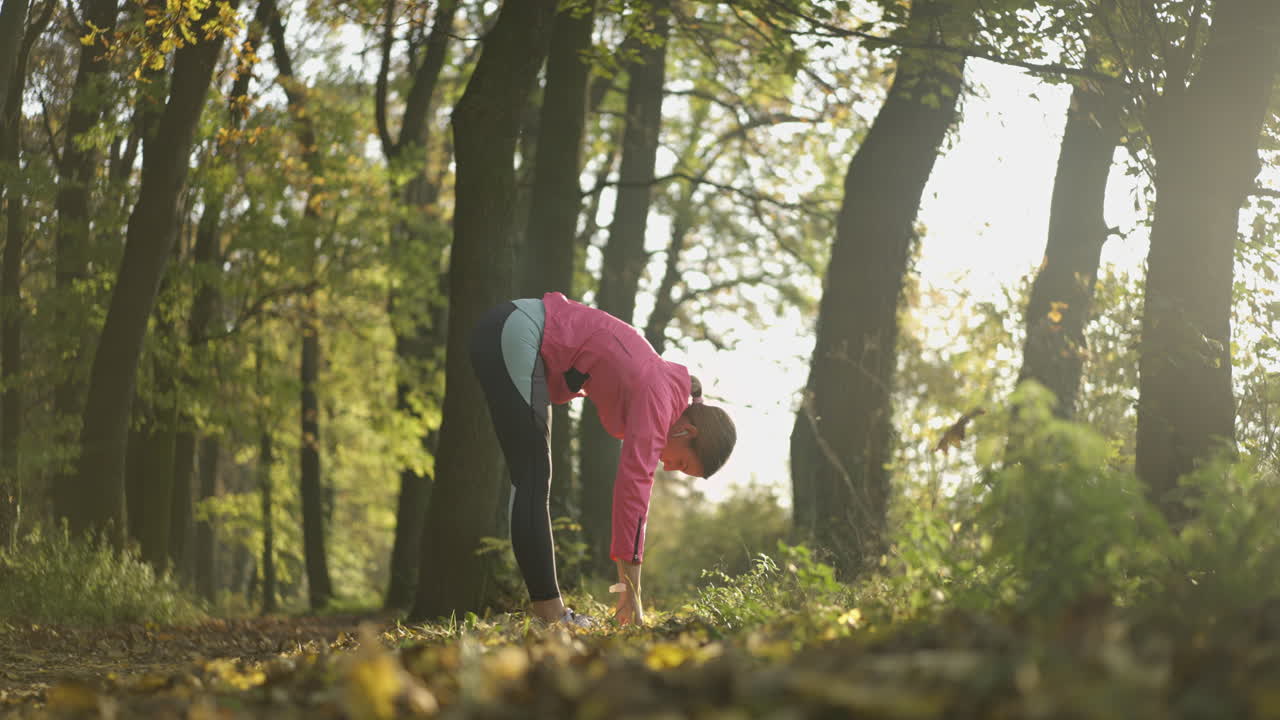 Woman stretching in a sunny autumn park