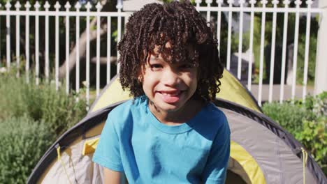 portrait of happy biracial boy son looking at camera in garden