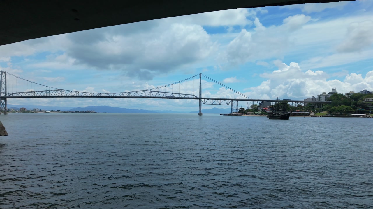 Pedro Ivo Campos Bridge in Florianópolis Santa Catarina Brazil over Baía Norte with Hercílio Luz Bridge revealed behind connecting island to mainland in Atlantic Ocean set, drone forward pass under
