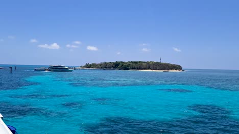 Blick-Vorbei-Am-Boot,-Das-Am-Pier-Auf-Der-Grünen-Insel-Angedockt-Ist,-Umgeben-Von-Türkisfarbenem-Wasser