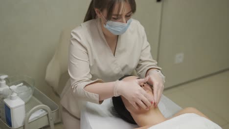 mujer hermosa con máscara facial en un salón de belleza