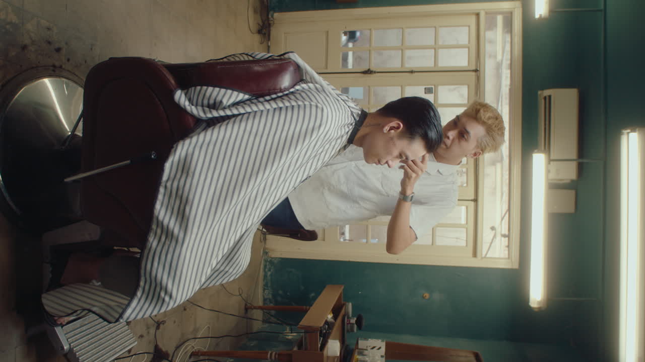 Male Client Sitting in Barbershop Getting Haircut