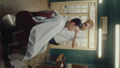 male client sitting in barbershop getting haircut