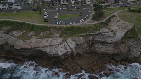 maroubra beach neighborhood houses drone zoom in close to the car park with ocean view at sunset