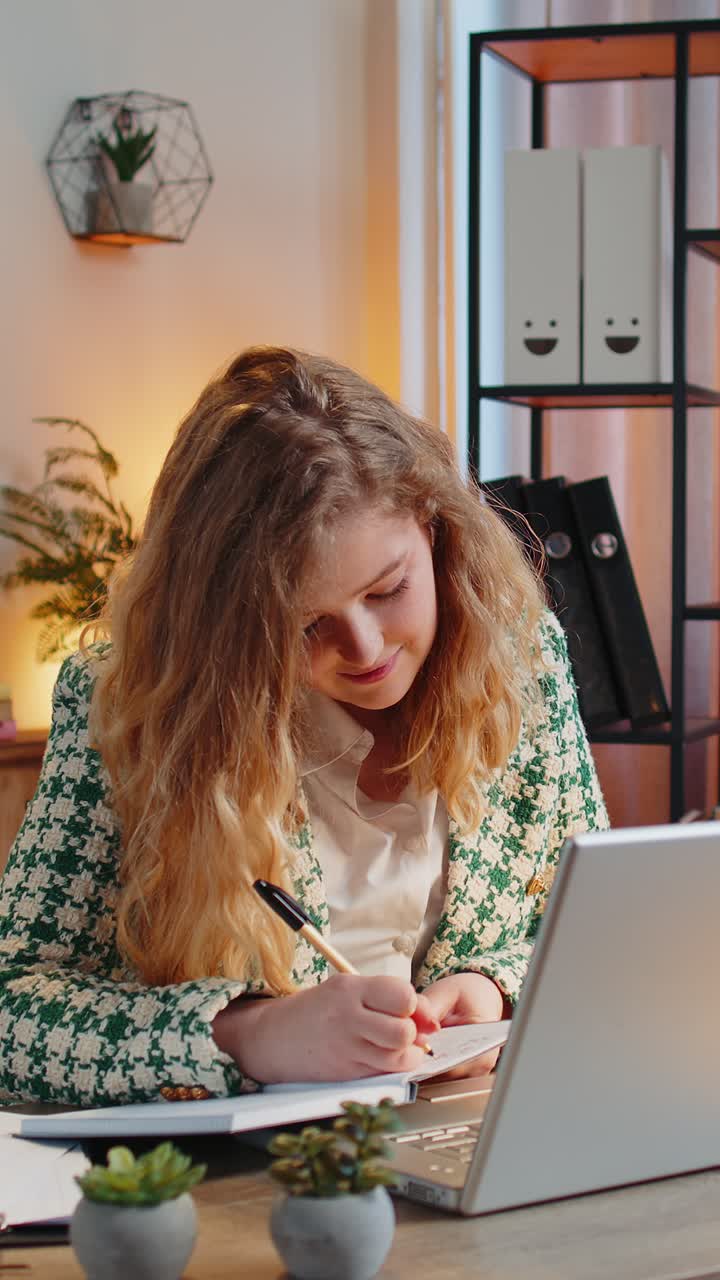 mujer de negocios escribiendo tomando notas mientras asiste a una reunión de clase de video en línea en una computadora portátil