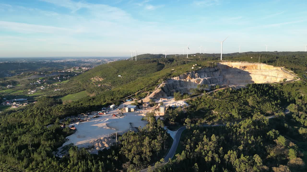 Vista aerea di una cava e turbine eoliche su una collina verde
