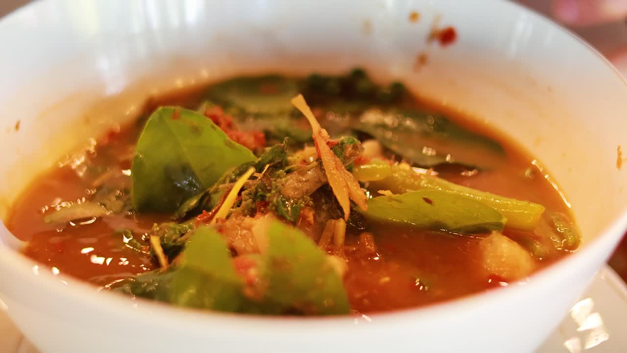 A vibrant Thai catfish curry is prepared, showcasing fresh ingredients and rich colors in a warm, inviting setting