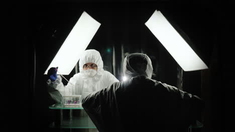 two scientists work in the lab in protective suits