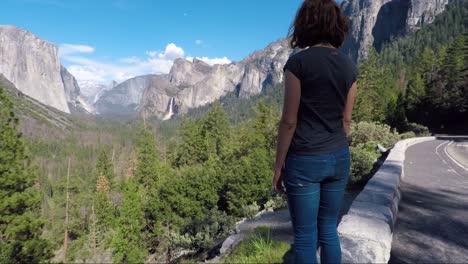 Young-woman-is-looking-at-the-Yosemite-valley-and-Bridal-veil-falls-from-Tunnel-View-in-Yosemite-National-park,-United-states-of-America