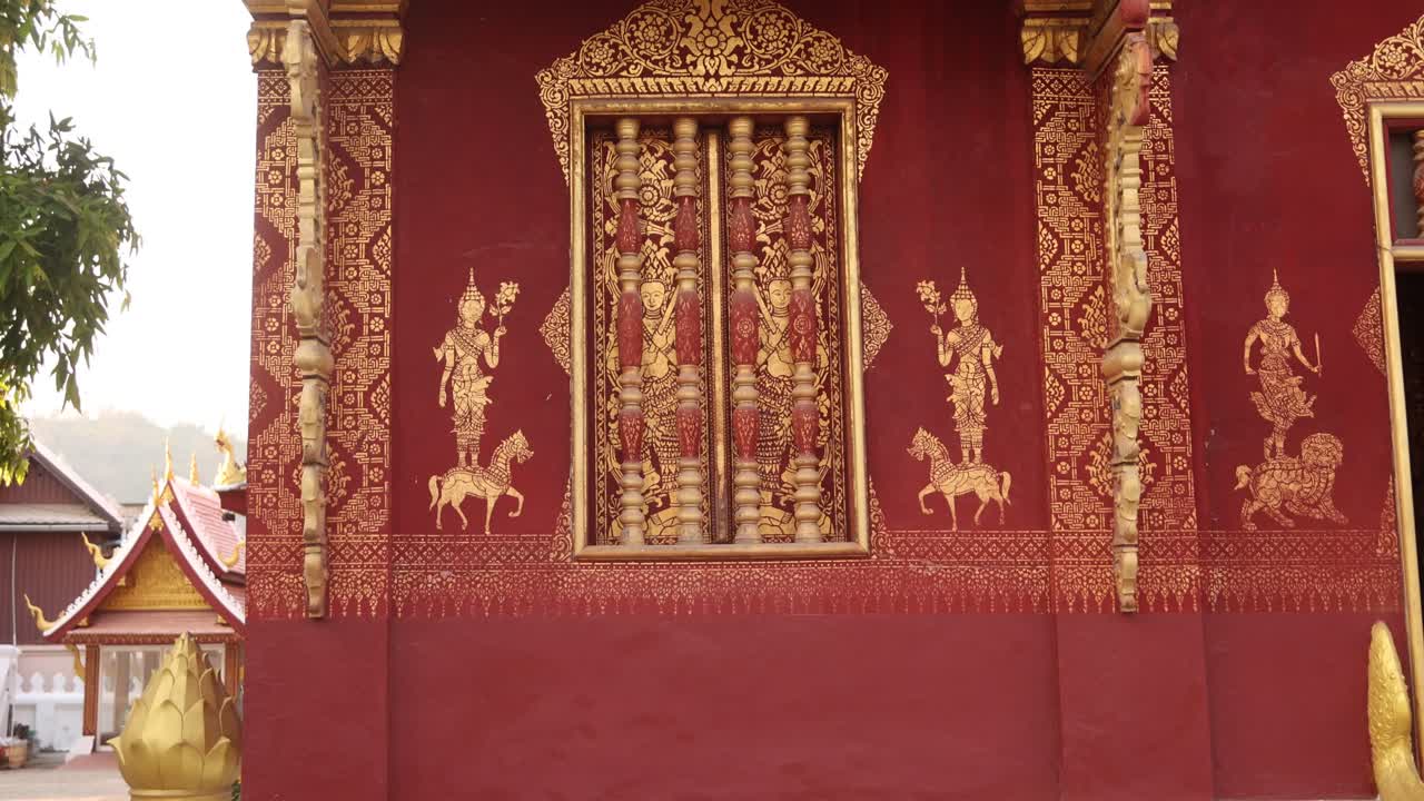 diseños rojos y dorados en el exterior del templo budista en luang prabang, laos viajando por el sudeste asiático