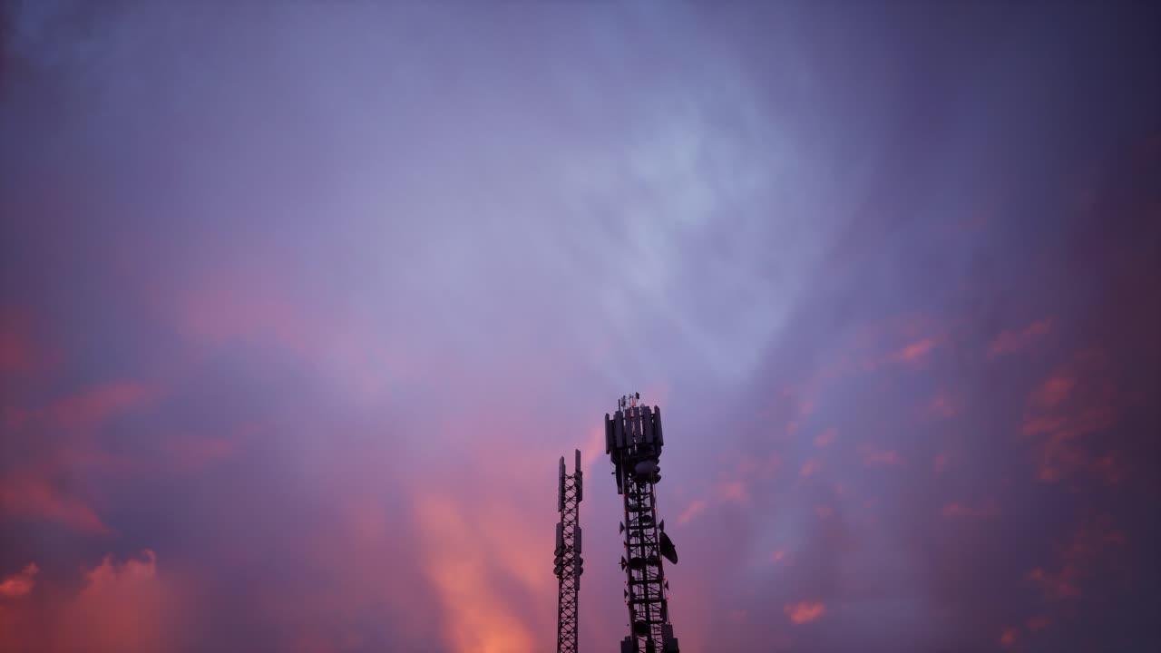 A Tall Cell Tower Stands Against A Vibrant Sunset