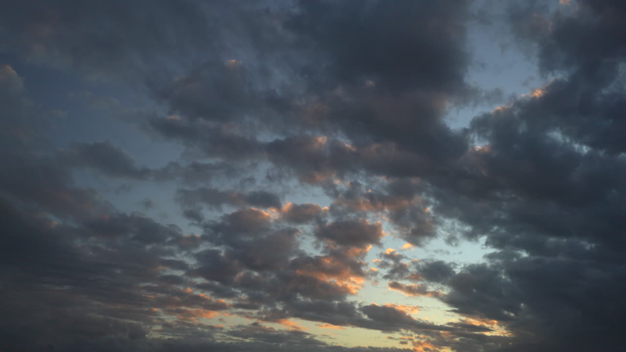 해가 지는 황금빛으로 하늘을 가로질러 움직이는 구름의 시간 흐름