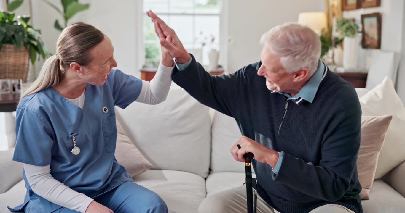 Female Nurse Giving High Five to Senior Man at Home