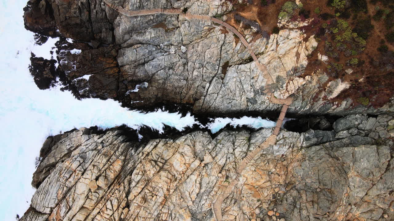 aéreo - costa rocosa y puente, zapallar, valparaíso, chile, plano general de arriba hacia abajo