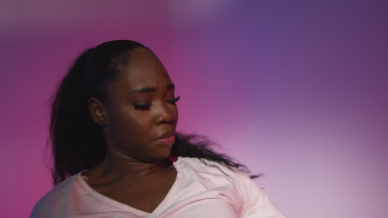 fotografía de estudio de una joven bailarina bailando contra un fondo iluminado de azul y rosa 15