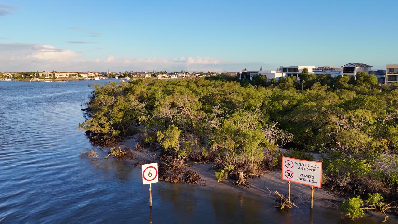Drone captures serene mangroves and waterway at Gold Coast. Clear skies and calm waters create a tranquil atmosphere