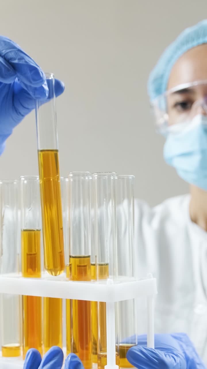 실험실 에서 실험 튜브 를 검사 하는 과학자