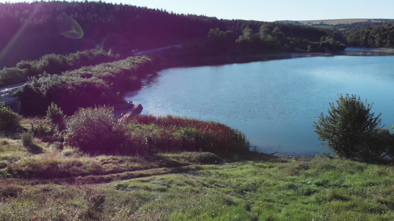 drone disparó sobre el campo de hierba verde y el lago a principios de la mañana de verano