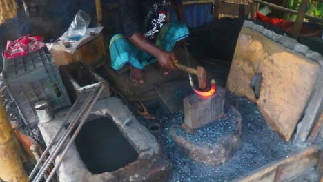 A-blacksmith-in-Dhaka,-Bangladesh,-shapes-a-hot-metal-bar-with-expert-precision