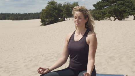 Inclinación-De-Mujer-Hermosa-Meditando-En-Dunas-De-Arena