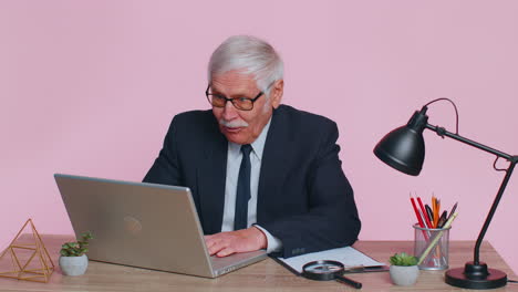 senior business office man analyzes financial charts celebrate success win at home workplace desk