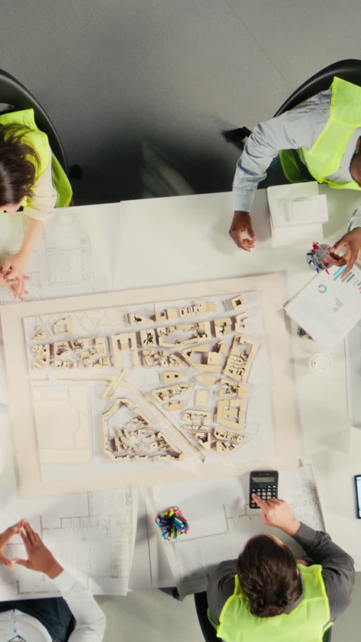 Vertical Video Top down view zoom in of architects working on real estate investment plan