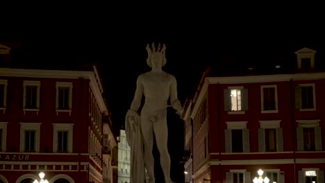 night view of a statue in a city square