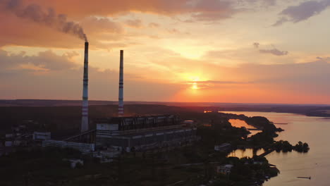 industrial refinery with smokestack near a river. amazing sunset at industrial zone. view from above. video from dron.