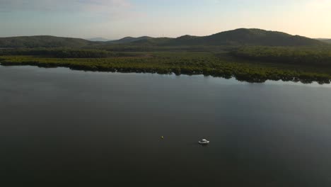 aerial view of a boat in a remote river at karuah at sunrise, northern new south wales.