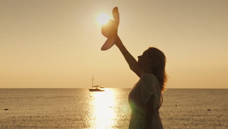 a woman waves her hat to a distant ship standing on the pier in the early morning meets the dawn 4k