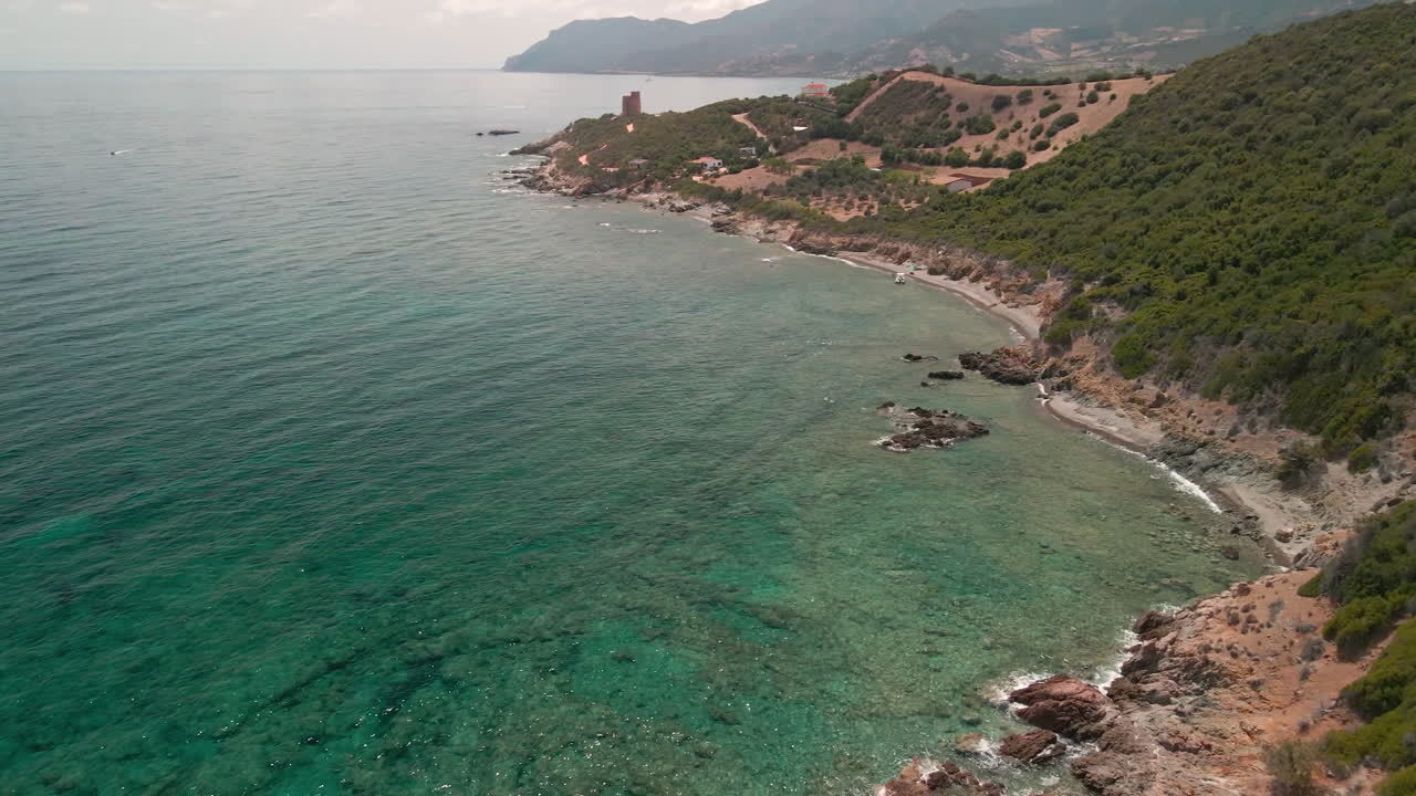 Scenic View Of Tropical Sea Water And Green Mountains On A Beautiful Sunny Day In Sardinia, Italy - aerial drone shot