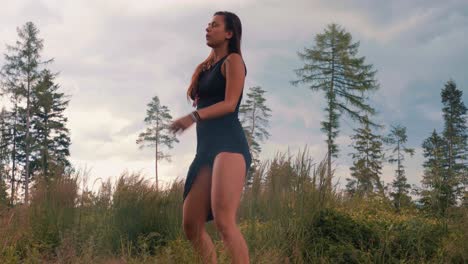 young woman dances with freedom outdoors in nature, medium shot