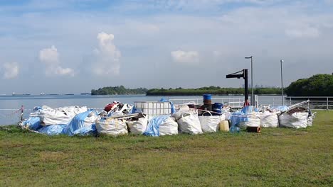 construction-materials-by-the-sea-used-for-ocean-clean-up-after-the-oil-spill-of-14th-june-2024-that-affected-Singapore's-southern-island