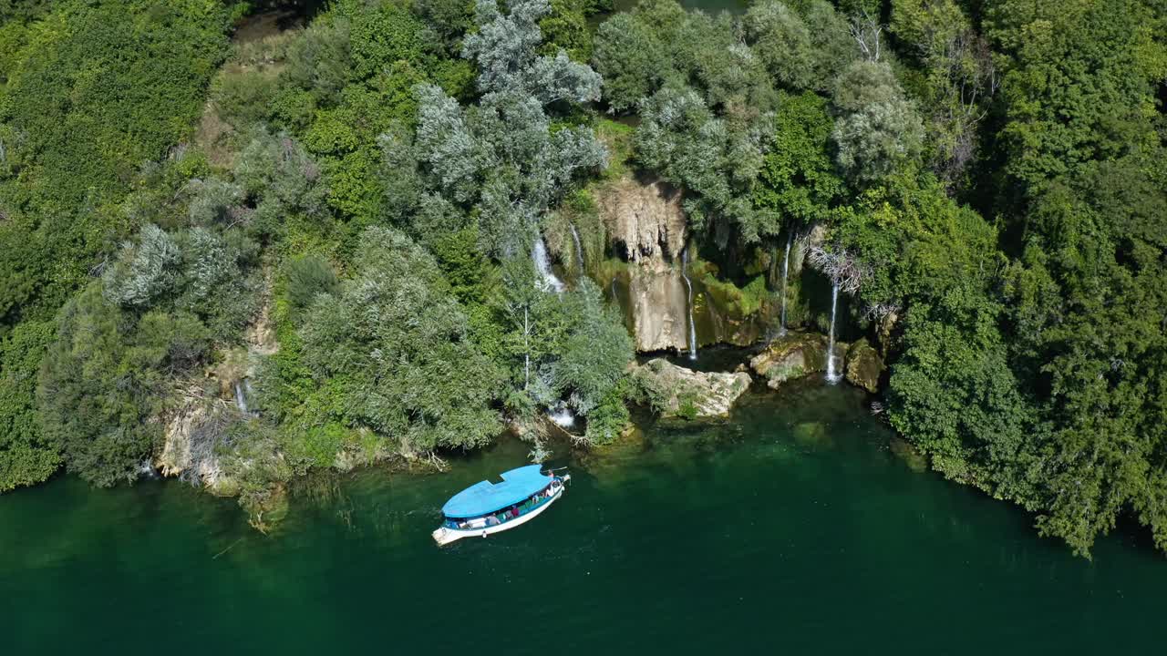 barco de crucero turístico cerca de la cascada de roski slap en el parque nacional de krka, croacia