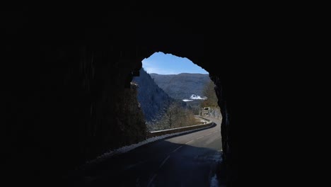 tiro de drone saliendo de un túnel con una hermosa vista a la montaña
